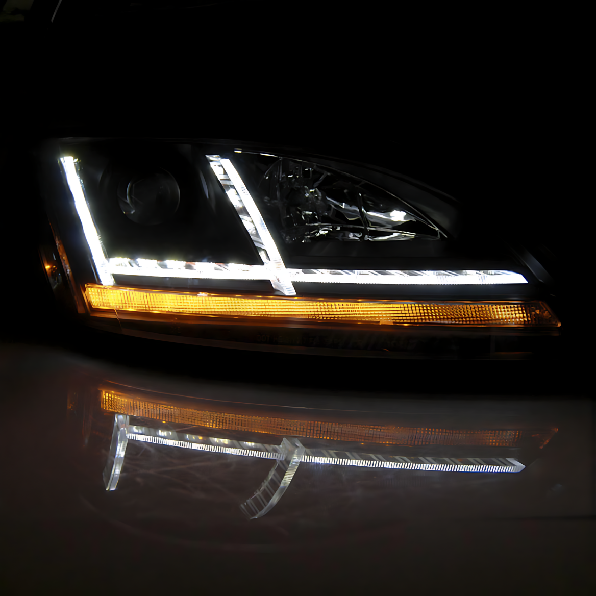 LED-Auto-Scheinwerfer bei Nacht mit weißem Tagfahrlicht und aktivem, amberfarbenem Blinker. Deutliche Reflexion auf der Oberfläche.